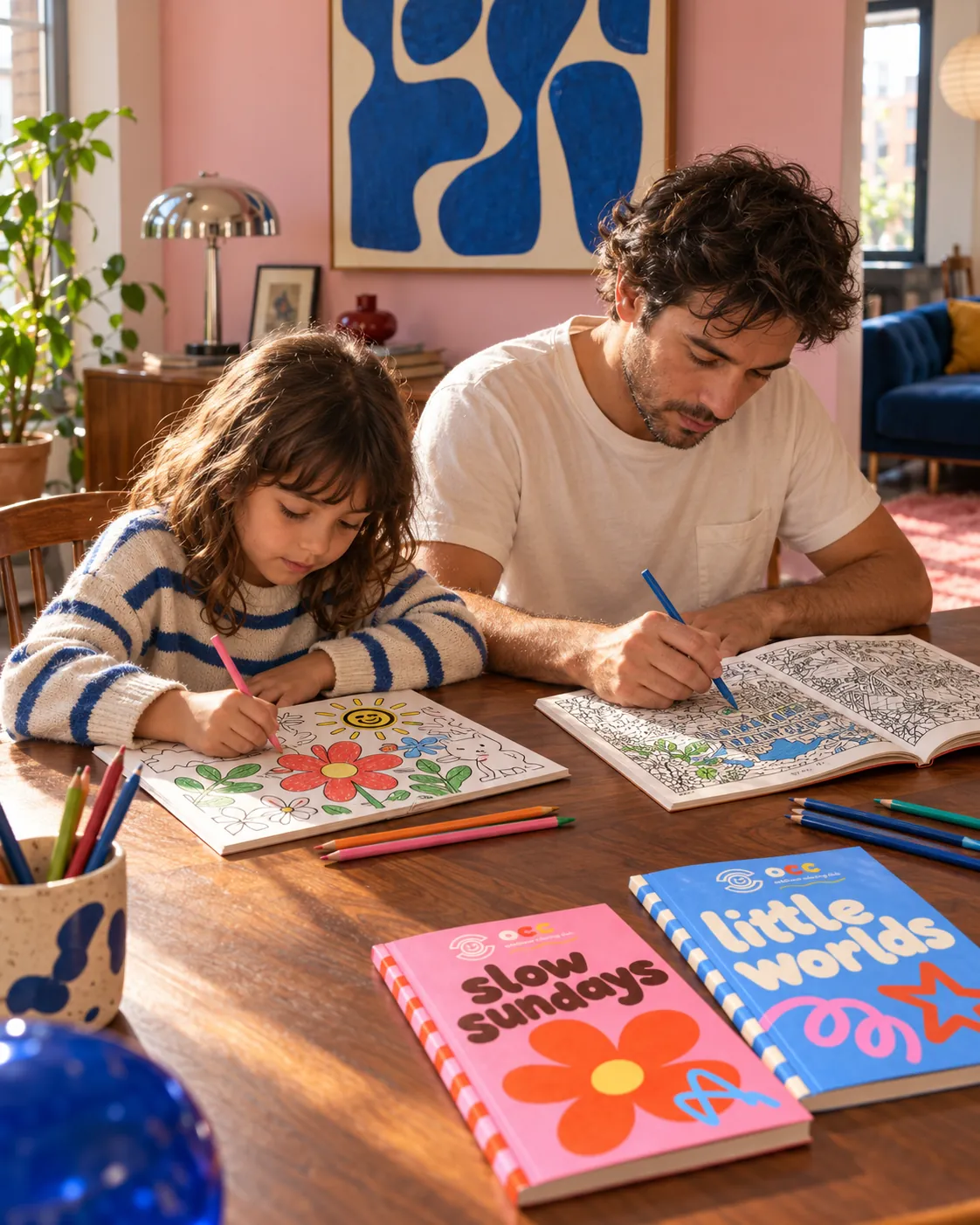 A father and daughter colouring side by side at a wooden table